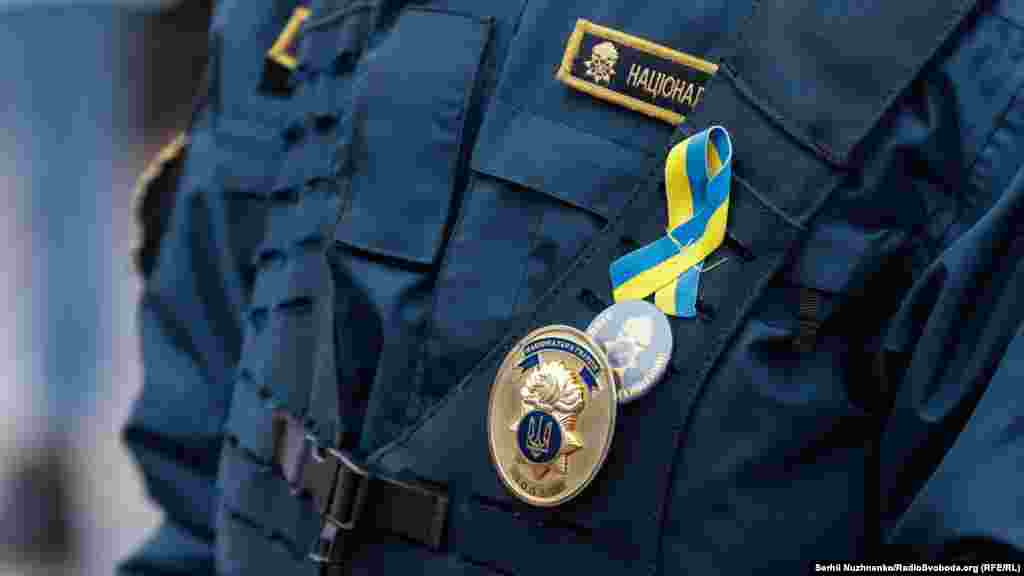 In Kyiv, a police officer wears a ribbon with the colors of the national flag. 