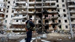 Čovjek ispred stambene zgrade u Kijevu pogođene u ruskim napadima