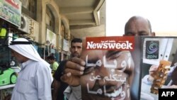 A man browses through an Arabic copy of "Newsweek" in Baghdad on June 3.