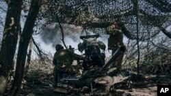 Ukrainian soldiers fire a cannon near Bakhmut in the Donetsk region. 