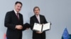 Belgium - EU Enlargement Commissioner Johannes Hahn (R) and Armenian Economy Minister Karen Chshmaritian sign a memorandum of understanding in Brussels, 3Nov2014.