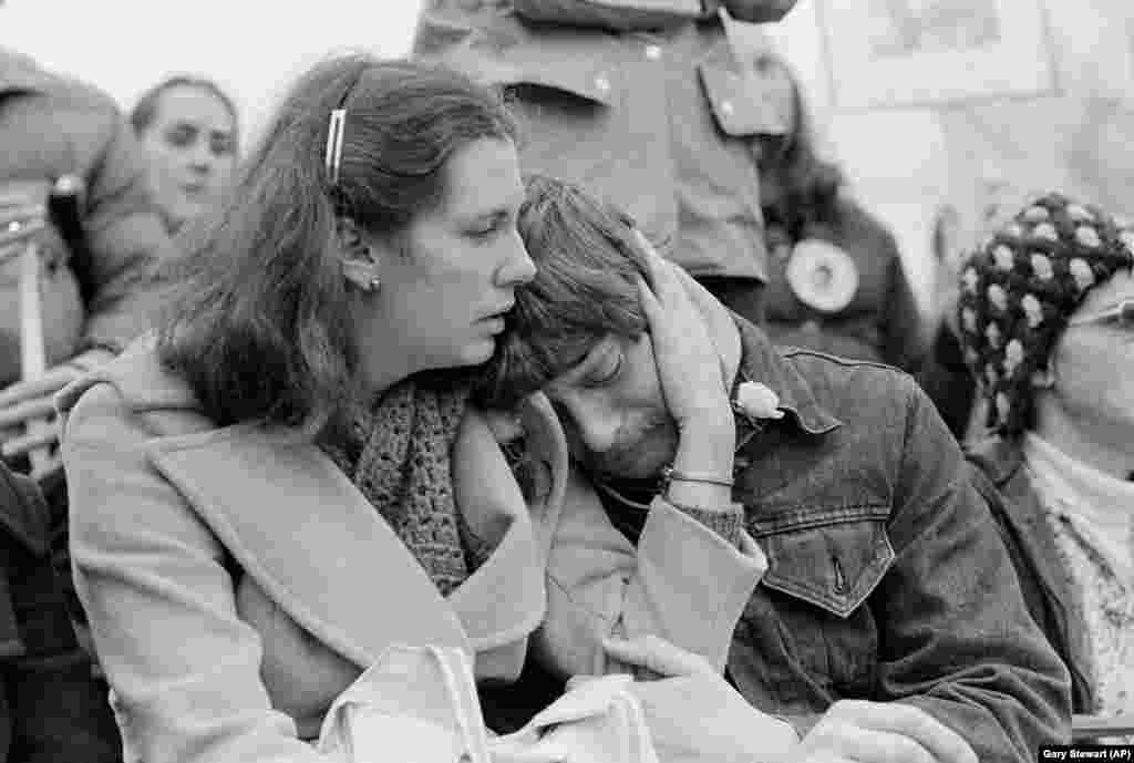 O femeie liniștește un bărbat care plânge, în ziua de 14 decembrie 1980, în Seattle, în timpul comemorării lui John Lennon, ucis la New York, 8 decembrie.