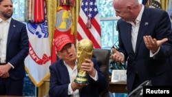Donald Tramp futbol üzrə dünya çempionatının kubokunu tutur.