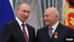 Russian President Vladimir Putin (left) speaks with former Moscow Mayor Yury Luzhkov after awarding him during a ceremony at the Kremlin in Moscow in September 2016.