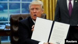 Дональд Трамп демонструє щойно підписаний меморандум про вихід США з угоди ТТП, Білий дім, Вашингтон, 23 січня 2017 року