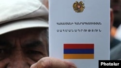 A protester holding an Armenian constitution, undated