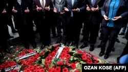 People pray after laying wreaths in front of the Reina nightclub on January 4 in Istanbul.