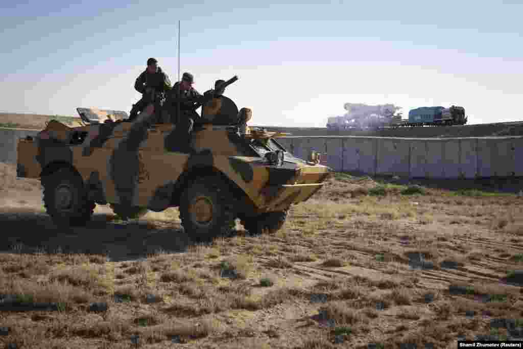 Russian military personnel watch from an armored vehicle as a Soyuz is transported to the launchpad. Baikonur is seen as a potential target for terrorist attacks. &nbsp;