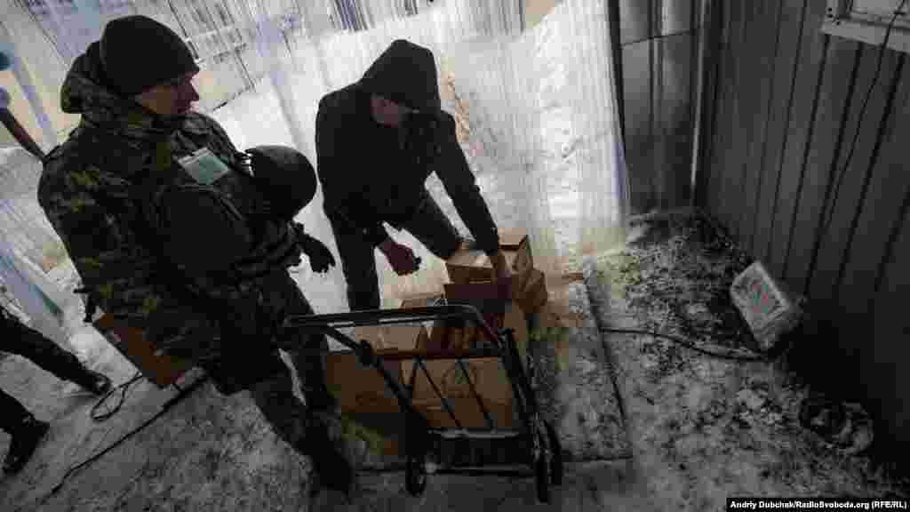 Boxes being weighed on a frosty set of scales. At 74.2 kilograms, this man's load falls just within the 75 kilograms each person is allowed to cross with.