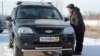 Житель Актобе рассматривает автомобиль, пригнанный из России на продажу в Казахстане. 19 декабря 2014 года.