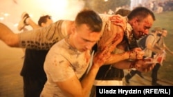 A protester injured in clashes with riot police is carried away by fellow opposition supporters in Minsk after polls closed in the Belarusian presidential election on August 9.