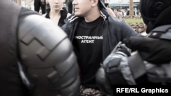 A protester wears a T-shirt that says "Foreign Agent." While the "foreign agent" laws do not themselves include criminal penalties, designees can face criminal charges and years in prison under other laws if they fail to comply properly.