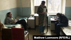 A nurse treats Ivan Korobenkov (left) and another TB patient at the treatment center in Chernavsky. Doctors at the center say they are forced to buy their own face masks since the state does not supply enough.