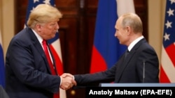 U.S. President Donald Trump (left) and Russia's Vladimir Putin shake hands at their Helsinki summit last year. 