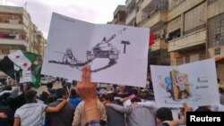 Anti-regime protesters march through the streets in Homs on October 30. 