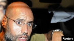 Saif al-Islam speaks to reporters in Tripoli on August 23.
