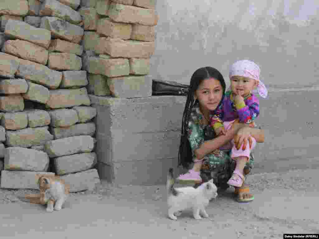 Ten-year-old Madina, an ethnic Uzbek, holds her niece in the courtyard of her family home in an Uzbek mahalla in the southern Kyrgyz city of Osh. Her family's home was destroyed by fire in the June 2010 ethnic clashes. A report by the international Kyrgyzstan Inquiry Commission says Uzbeks made up three-fourths of the 470 people killed in the clashes and also sustained the majority of the property damage.