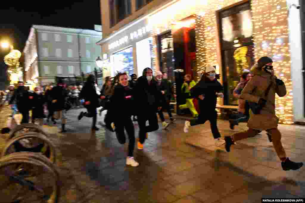 People run from security forces in Moscow early on February 3.