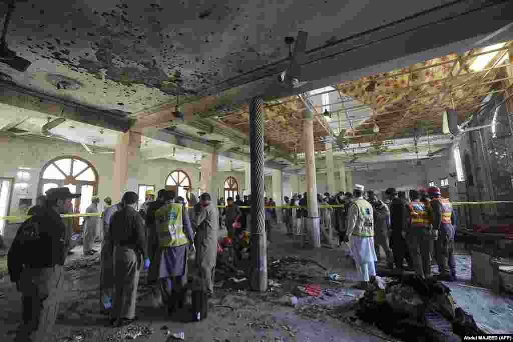 Agenții de securitate pakistanezi investighează locul exploziei.