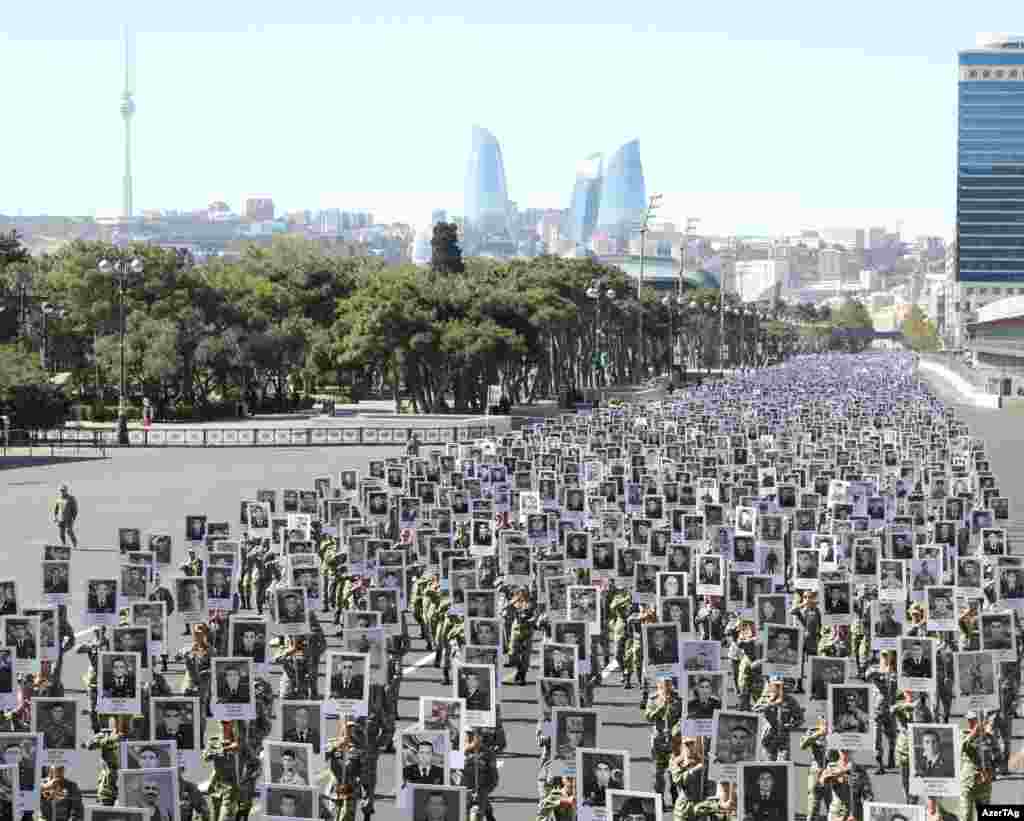 Thousands of soldiers march through Baku on September 27. The marchers are holding placards depicting soldiers and civilians killed in 2020, the most intense escalation since the 1994 truce that turned the war between Armenia and Azerbaijan over the Nagorno-Karabakh region into a "frozen conflict."