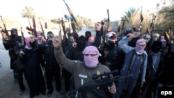 Masked Sunni gunmen chant slogans against Iraq's Shi'ite-led government during a protest in Fallujah on January 7.