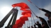 Kyrgyzstan -- Men wearing their traditional hats hold national flags during a rally marking the "National Flag Day" in Bishkek, March 3, 2015
