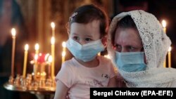A Russian woman with a child attends the Trinity Sunday holiday service at Yelokhovsky Epiphany Cathedral in Moscow on June 7.