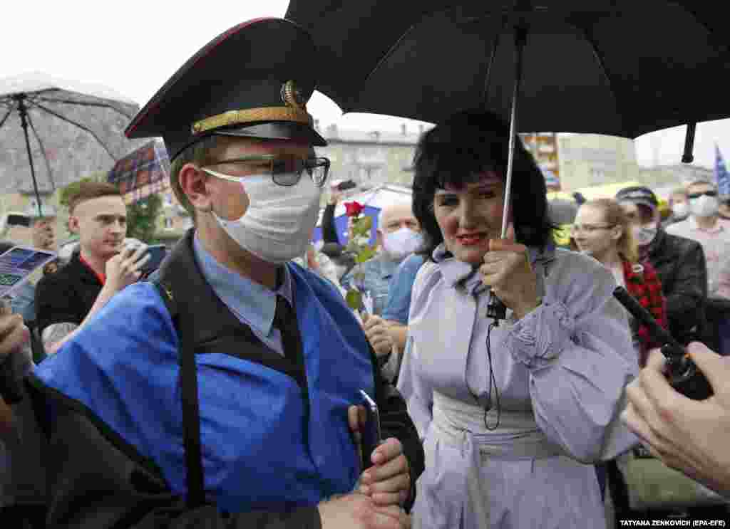 A police officer watches opposition supporters during the rally in Minsk.