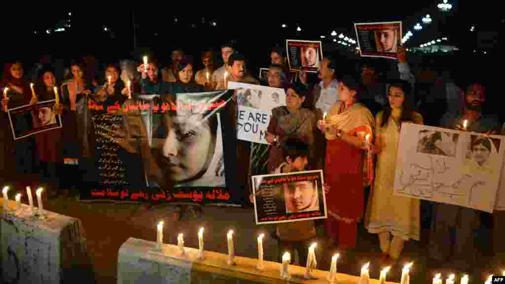 Civil society activists and journalists carry candles and photographs of Yousafzai during a protest against the Taliban's attempt on her life in Islamabad on October 11, 2012.